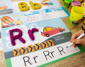 May include: A child's learning activity set featuring a red race car and a purple playdough letter R. The letter R is being traced with a white marker on a white sheet with black lines. The sheet has the words "R is for RACE CAR" printed on it.