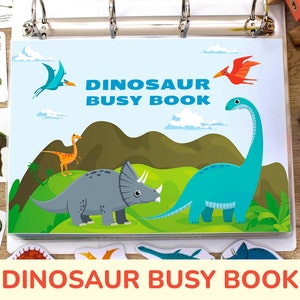 May include: A colorful dinosaur busy book with a blue, green, and orange cover. The cover features the text "Dinosaur Busy Book" and illustrations of dinosaurs.