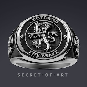 Peut inclure: Une bague en argent avec un motif en émail noir représentant le lion écossais rampant et les mots "Scotland The Brave".