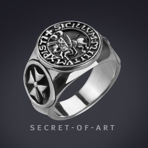 May include: Silver ring with a round seal featuring a knight on horseback and the inscription "S.P.D.N. REX. SICIL. ET. HIER. REX." The ring also has a Maltese cross on the side.