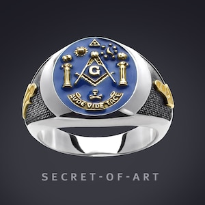 May include: A silver Masonic ring with a blue enamel inlay featuring a compass and square, a 'G' in the center, and the Latin phrase "Aude Vide Tace".