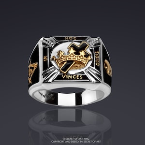 May include: A silver ring with a black enamel inlay featuring a gold crown, cross, and the text "HOC SIGNO VINCES".