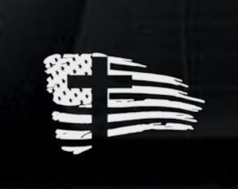 May include: Two car decals featuring a distressed American flag with a cross in the center. The top decal is white on black, and the bottom decal is black on red.
