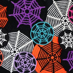 Puede incluir: Una colección de telarañas de ganchillo de colores, en varios tamaños y colores, incluyendo naranja, morado, rosa y turquesa, sobre un fondo negro. Estos artículos decorativos son perfectos para Halloween.