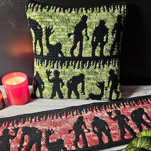 Puede incluir: Un cojín y un camino de mesa de ganchillo con temática de Halloween. El cojín presenta siluetas de zombis negros sobre un fondo verde y negro. El camino de mesa tiene un diseño de llamas rojas y negras con siluetas de zombis.