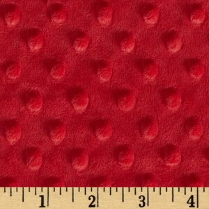 May include: Red minky fabric with a textured dot pattern. The fabric is shown with a ruler for scale.