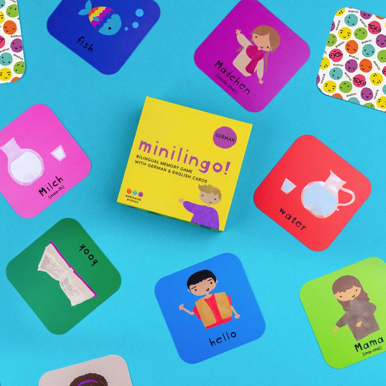 Pu&ograve; includere: Una scatola quadrata gialla con l'etichetta minilingo! bilingual memory game with German and English cards, circondata da carte quadrate colorate con illustrazioni di un pesce, una ragazza, latte, acqua, un libro, una persona e una madre.