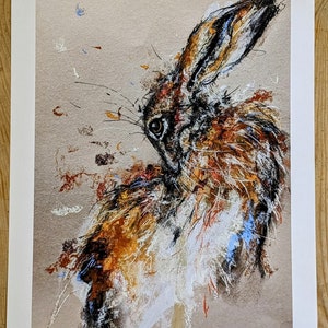 May include: A limited edition print of a brown and white hare with a textured background. The print is numbered 25/100 and signed by the artist, "Lucid Gray Norman".