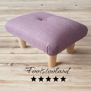 May include: A purple upholstered footstool with four wooden legs. The footstool has a button tuft on the top. The text "Footstooland" and five stars are visible below the footstool.
