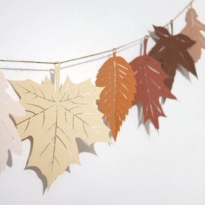 Ghirlanda di foglie autunnali marroni, striscione di foglie di carta in colori autunnali neutri. Ringraziamento ecologico, sfondo per matrimonio, decorazioni autunnali per la casa.