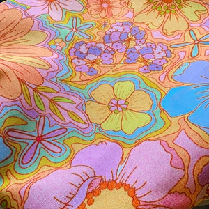 May include: A close-up of a fabric with a vibrant floral pattern. The design features large, stylized flowers in shades of orange, pink, yellow, and blue. The background has a wavy, abstract design in complementary colors, creating a retro, psychedelic aesthetic.