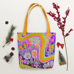 May include: Tote bag with a colorful, whimsical design. The bag features a rainbow, butterflies, flowers, and mushrooms against a purple and blue background. It has yellow handles.