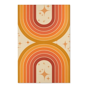 May include: A retro-style rectangular rug featuring a symmetrical design of two arched rainbows in shades of orange, red, and yellow. The background is a light beige with scattered starburst shapes. The rug has a soft, inviting aesthetic.