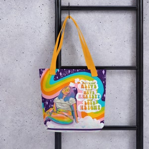 May include: A tote bag with a vibrant design featuring a seated figure with blue hair, a rainbow, and the text "You're not alive to just have anxiety and lose height." The bag has orange handles and a purple background.