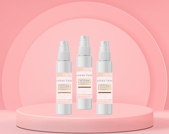 Op de afbeelding: Drie witte spuitflessen met gouden etiketten waarop "Luster Skin Products Crown Care Lace Tint Spray" staat. De flessen staan op een roze platform met een roze achtergrond.