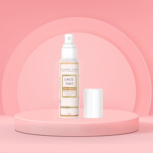 Könnte beinhalten: Eine 118 ml Flasche Crown Care Hair Products Lace Tint in Hellbraun. Die Flasche ist eine weiße Sprühflasche mit einem goldenen Etikett. Das Etikett trägt die Aufschrift "Lace Tint" und "Light Brown" in goldenen Buchstaben. Das Etikett trägt außerdem die Aufschrift "Semipermanente Haarfarbe Spray".