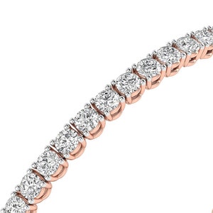 Puede incluir: Una pulsera de tenis de oro rosa con una serie de diamantes redondos con talla brillante. Los diamantes est&aacute;n engastados muy juntos, creando una l&iacute;nea continua de brillo. La pulsera se muestra sobre un fondo blanco.