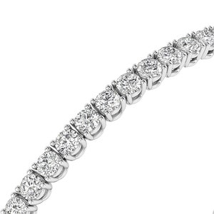 Puede incluir: Primer plano de una pulsera de tenis con una serie de diamantes redondos con talla brillante engastados en metal blanco. Los diamantes brillan sobre un fondo blanco, mostrando el elegante dise&ntilde;o de la joya.