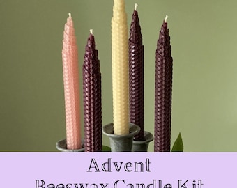 May include: Five tapered beeswax candles with a textured honeycomb pattern, arranged in a holder. The candles are in shades of light pink, deep purple, and cream. The text Advent Beeswax Candle Kit is displayed at the bottom of the image.