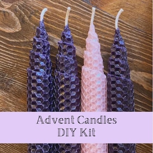 May include: Four tapered candles with a textured honeycomb pattern. Three candles are deep purple and one is light pink. Each candle has a white wick at the top. A light purple banner across the bottom displays the text Advent Candles DIY Kit.