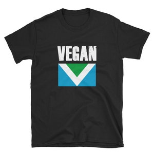 May include: Black t-shirt with the word "VEGAN" in white letters and a green, white, and blue vegan flag.