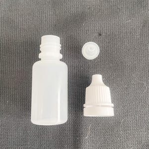 Op de afbeelding: Een witte plastic fles met een druppelaar en een aparte witte dop. De fles is leeg en klaar om gevuld te worden.