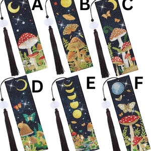 May include: Six decorative bookmarks with a dark blue background and various designs. Each bookmark features a different illustration, including mushrooms, moons, butterflies, and celestial elements. Each bookmark has a black tassel and a white bead.