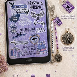 May include: Fantasy Kindle accessory set featuring a Kindle with stickers, a dust plug charm, and a dragon pendant bead charm. The Kindle case has stickers with phrases like "Spicy Fairytales" and "Book Lover".