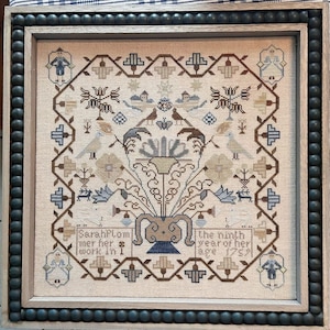 Puede incluir: Un sampler enmarcado con un diseño floral y el texto "SarahPlom mer her work in I the ninth year of her age 1752".