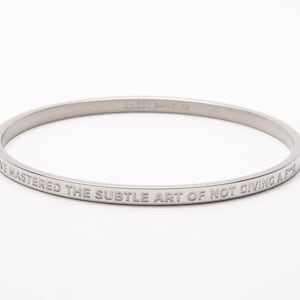 He dominado el sutil arte de que no me importe nada. Brazalete inspirador de plata grabado con hermosas citas de por vida.