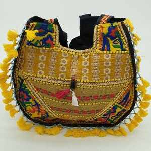 Può includere: Una borsa di patchwork gialla, nera e blu con un dettaglio a nappa. La borsa è realizzata in tessuto e ha un design unico e fatto a mano.