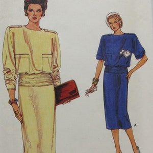 May include: A sewing pattern for a dress, Vogue Very Easy pattern number 9180, sizes 14-16-18. The pattern shows two versions of the dress, one in yellow and one in blue.
