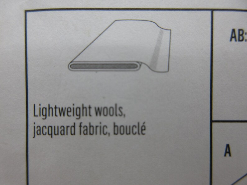 May include: Diagram of a fabric cross-section, showing a rolled edge and a layered construction. The text below reads: Lightweight wools, jacquard fabric, boucl&eacute;.