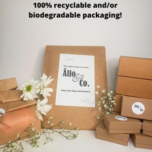 May include: A close-up of a brown paper package with the text "Your happy package has arrived! All&ocirc; & Co. etsy.com/shop/ALLOandCO" printed on it. The package is surrounded by white flowers and smaller brown boxes with the same logo.