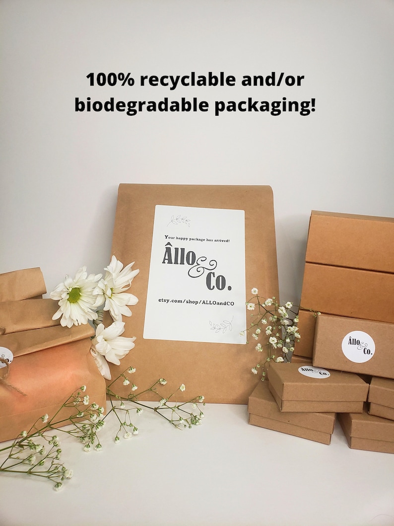 May include: A close-up of a brown paper package with the text "Your happy package has arrived! All&ocirc; & Co. etsy.com/shop/ALLOandCO" printed on it. The package is surrounded by white flowers and smaller brown boxes with the same logo.