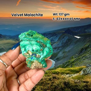 May include: A Velvet Malachite stone, weighing 137 grams and measuring 6.2x4.4x4.0 cm. The stone's vivid green hue and textured surface are visible. The image includes the text "Velvet Malachite" and a scenic mountain backdrop.