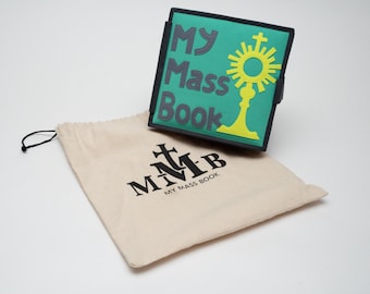 May include: A green "My Mass Book" with gray lettering and a yellow religious symbol. The book is next to a beige drawstring bag with the text "MMB MY MASS BOOK" printed in black.