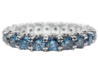 May include: A silver band ring with a row of blue diamonds.