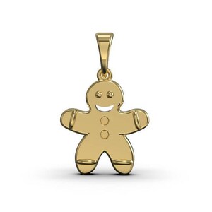 Könnte beinhalten: Ein goldfarbener Lebkuchenmann-Anhänger. Der Anhänger ist eine einfache Umrandung eines Lebkuchenmannes mit einem lächelnden Gesicht und Knöpfen.