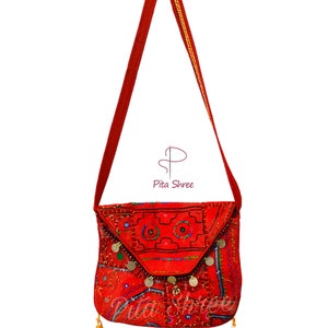 Peut inclure: Sac à bandoulière rouge brodé avec des garnitures dorées et des accents de pièces de monnaie. Le sac a une fermeture à rabat et un détail de pompon. Le sac est en tissu et a un style bohème unique.