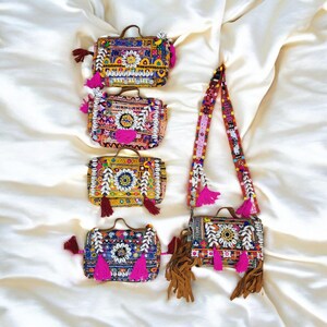 Puede incluir: Cinco bolsos de bandolera bordados de colores vivos con flecos y borlas. Los bolsos están decorados con cuentas, conchas y motivos florales.