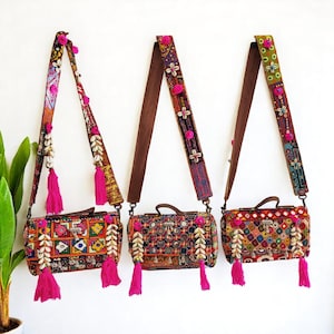 May include: Three colourful patchwork fabric crossbody bags with pink tassels and beaded straps. Each bag has a different pattern and features shell accents.
