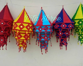 May include: Five colorful fabric lanterns with mirrored accents and tassels. The lanterns are in shades of red, yellow, blue, and green.