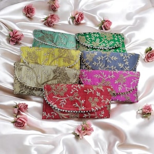 Könnte beinhalten: Sechs bestickte Clutch-Taschen in verschiedenen Farben, darunter Grün, Gelb, Beige, Grau, Rosa und Rot. Jede Clutch hat ein florales Design mit goldfarbenem Garn und eine Reihe von Perlen am Rand.