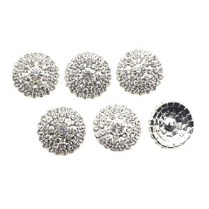 May include: Six silver-toned round buttons with clear rhinestones. The buttons are about 1 inch in diameter.