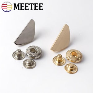 May include: Two sets of metal snap fasteners, one set in silver and one set in gold. Each set includes a snap, a stud, and a cap.