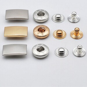 May include: Assortment of metal snap fasteners in silver and gold finishes. The snaps include both the male and female parts, as well as the decorative caps.