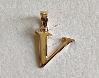 May include: Gold-toned pendant charm in the shape of the letter V. The pendant has a simple, elegant design.