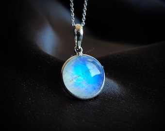 May include: A silver chain necklace with a round pendant featuring a blue and white moonstone. The pendant has the text "KK Gems & Jewels" inscribed on it.