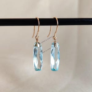 Pendientes de oro macizo de 14 quilates con topacio azul cielo natural, piedra natal de diciembre.